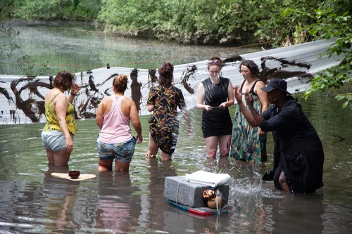 Gruppe von Menschen steht im Wasser.
