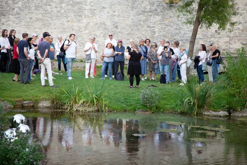 Eine Gruppe steht an der Dielenpader. Im Vordergrund sieht man das Wasser, in dem sich eine Bubble der Installation "Be Pader, my friend" von Manfred Webel befindet.