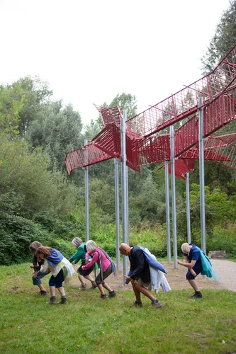 Die Performer und Performerinnen der Performance Gruppe Flusswärts tanzen vor dem Kunstwerk von raumlaborberlin.